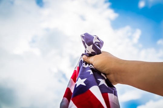 A person proudly waving an American flag in the air